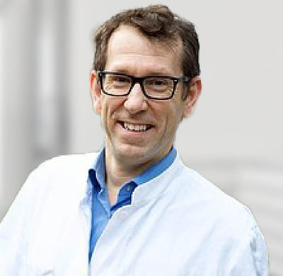 Un professionnel souriant et portant des lunettes